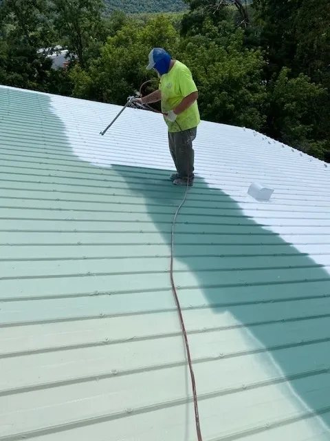 A man applying the roof coating