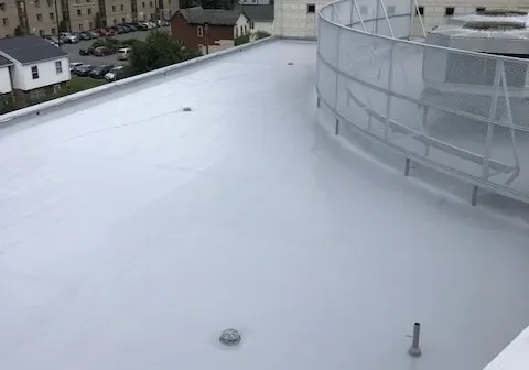 White flat rooftop with curved metal railing